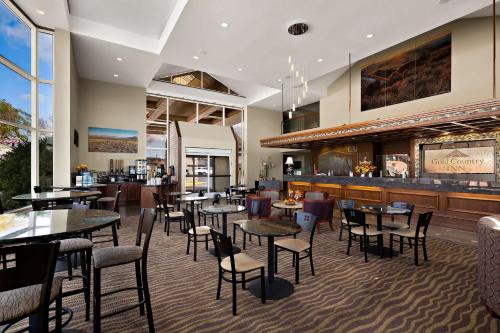 Best Western Plus Gold Country Inn في وينيموكا: مطعم به طاولات وكراسي وبار