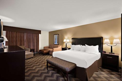 a hotel room with a large bed and a chair at Best Western Plus Gold Country Inn in Winnemucca