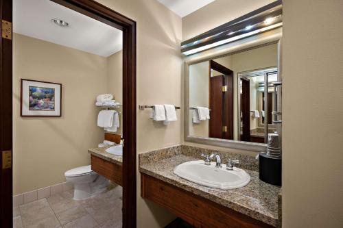 uma casa de banho com um lavatório, um WC e um espelho. em Best Western Plus Gold Country Inn em Winnemucca