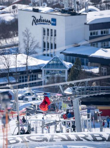 a person on a ski lift in the snow at Radisson Blu Resort, Beitostølen in Beitostøl