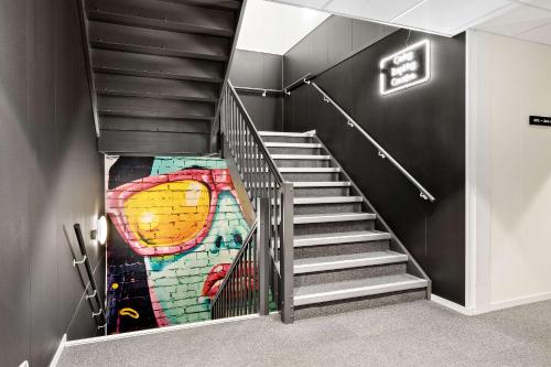 a staircase with a painting on the wall at Aiden by Best Western Harstad Narvik Airport in Harstad