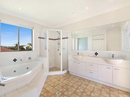 a bathroom with two sinks and a tub and a shower at Montego Sands Resort in Gold Coast