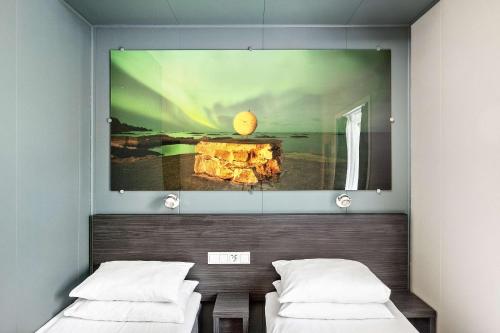 a room with two beds and a painting on the wall at Aiden by Best Western Harstad Narvik Airport in Harstad