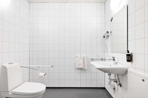 a white bathroom with a toilet and a sink at Aiden by Best Western Harstad Narvik Airport in Harstad