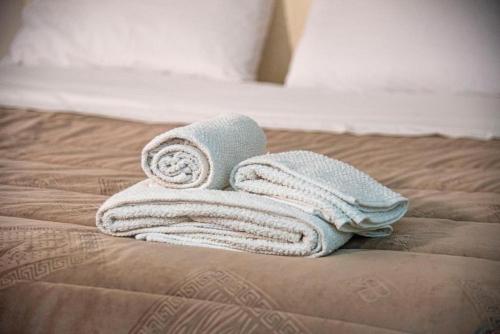 a pile of towels sitting on top of a bed at Campania Apartment Pompei Luxury - 150m dalla stazione - 5km da Pompei in Poggiomarino