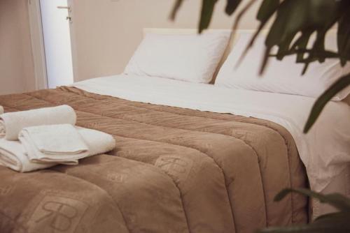 a bed with two towels on top of it at Campania Apartment Pompei Luxury - 150m dalla stazione - 5km da Pompei in Poggiomarino
