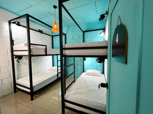 a room with three bunk beds in a building at Lolas Hostal, Habitacion Exclusiva para Mujeres, 2 camarotes, precio por cama in San José