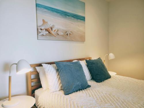 a bedroom with a bed with blue and white pillows at CityViews @ Glenelg * Pool/Beach * Free Parking * in Glenelg