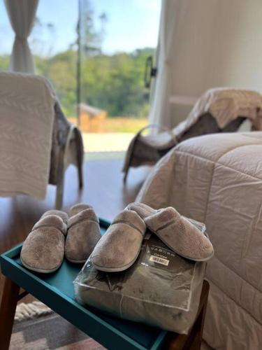 a pair of shoes sitting on a table next to a bed at Lake House_SC in Rio Forcação