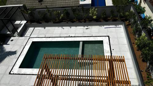 an overhead view of a swimming pool with a wooden fence at Palulu Flat - Conforto e Conveniência Garantidos - Ar Condicionado - Área de Lazer com Piscina e Sauna - Garagem Subterrânea - Serviço de Praia in Juquei