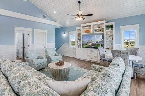 a living room with a couch and chairs and a tv at Nauti Captain in Port Aransas