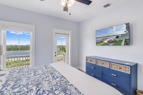 a bedroom with a blue bed and a balcony at Nauti Captain in Port Aransas