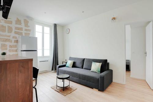 un salon avec un canapé et une cuisine dans l'établissement Peaceful apartment - 1BR 4P - Levallois-Perret, à Levallois-Perret