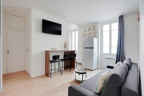 un salon avec un canapé et une cuisine dans l'établissement Peaceful apartment - 1BR 4P - Levallois-Perret, à Levallois-Perret