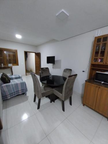 sala de estar con mesa, sillas y cama en Duplex novo en Tramandaí