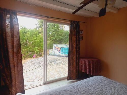 a bedroom with a window with a view of a yard at Altos del María, Panamá in Sorá
