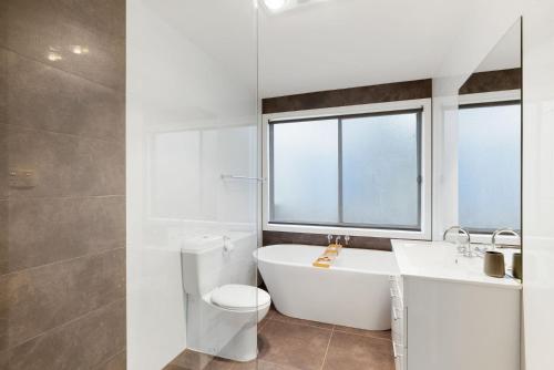 a bathroom with a tub and a toilet and a sink at Florida Bliss in Smiths Beach