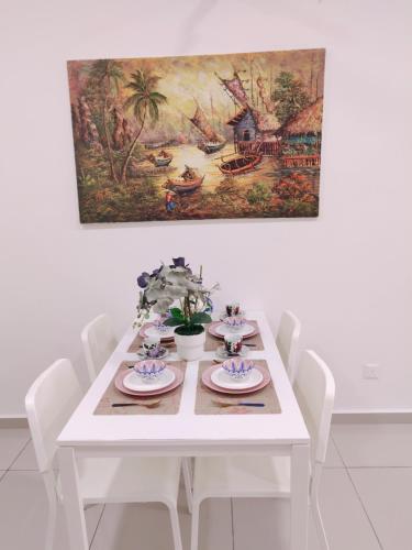 a white table with white chairs and a painting on the wall at WAGHEIH KOMEY HOMESTAY in Putrajaya