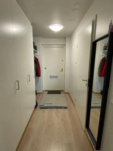 pasillo con puerta y espejo en la habitación en Cozy apartment in Rastila, en Helsinki