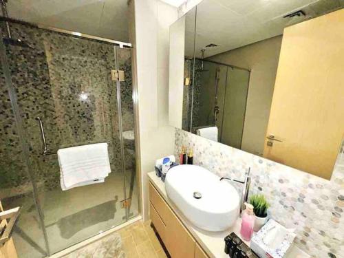 a bathroom with a sink and a glass shower at Mayan Studio Apartment in Abu Dhabi