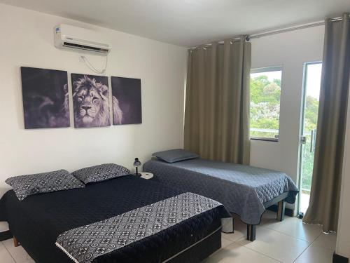 1 Schlafzimmer mit 2 Betten und einem Fenster in der Unterkunft Casa em Escarpas do Lago in Capitólio