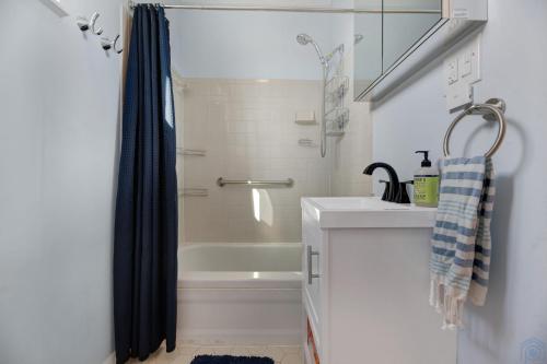 een witte badkamer met een douche en een wastafel bij Historic Petworth Homestay in Washington