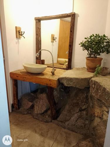 a bathroom with a sink and a mirror on a table at Refugio de Ángeles in Salsipuedes