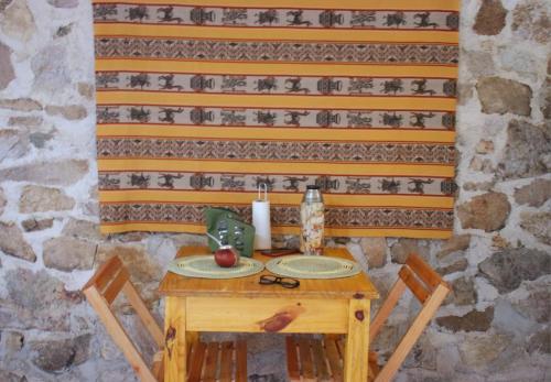 a wooden table with two chairs and an apple on it at Refugio de Ángeles in Salsipuedes