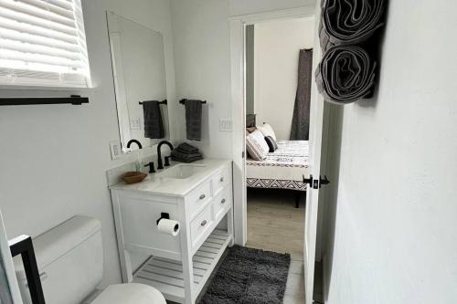 a white bathroom with a sink and a mirror at *NEW* Beautiful LakeSide #2 Home in Porum
