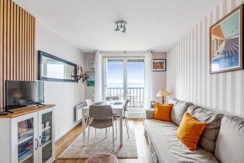 un salon avec un canapé et une table dans l'établissement Appartement Loma - Welkeys, à Blonville-sur-Mer