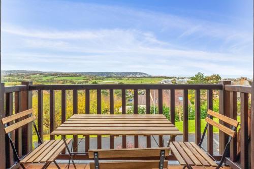 une table en bois et deux chaises sur un balcon dans l'établissement Appartement Loma - Welkeys, à Blonville-sur-Mer