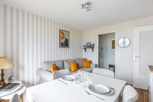 un salon avec une table blanche et un canapé dans l'établissement Appartement Loma - Welkeys, à Blonville-sur-Mer