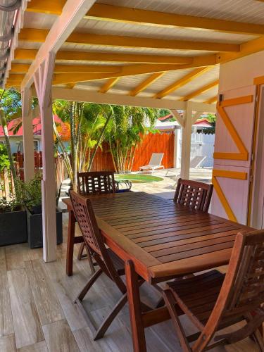 a wooden table and chairs on a patio at Villa KER IGUANE Terre de Haut Les saintes in Terre-de-Haut