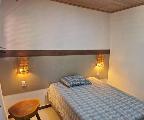 a bedroom with a bed and a chair and lights at Casa linda na Praia do Francês! Caribe Alagoano in Marechal Deodoro