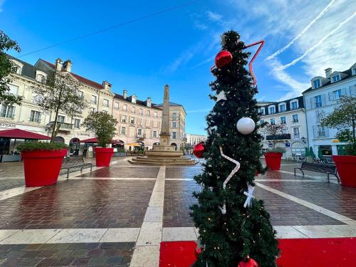 a christmas tree in the middle of a street at Appt Vue Place de Toscane - 4min Disneyland-PARIS in Serris