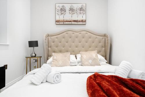 1 dormitorio con 1 cama blanca grande con manta roja en The calm apartment with 2 ensuite bedrooms. en Preston