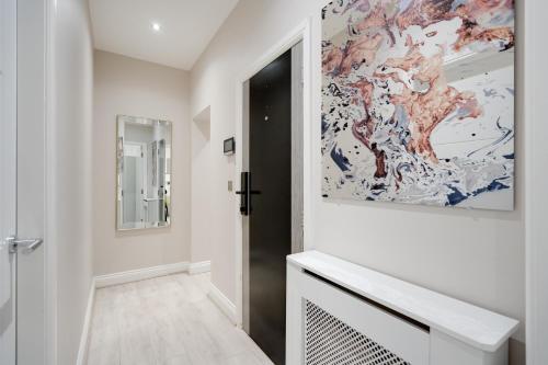 a hallway with a door and a painting on the wall at The calm apartment with 2 ensuite bedrooms. in Preston
