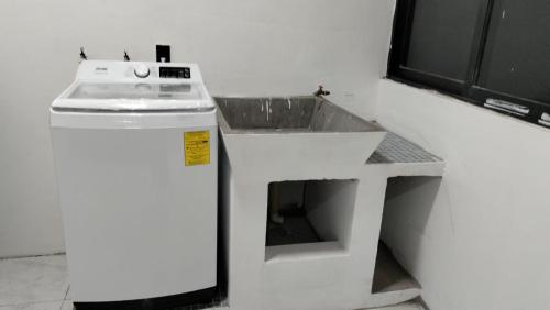 a white kitchen with a sink and a counter at Lidxi Stagabeñe in Juchitán de Zaragoza