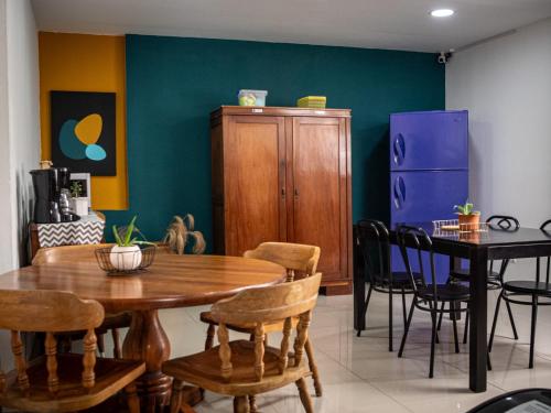 聖何塞的住宿－Lolas Hostal Apartamento Equipado，一间带木桌和椅子的用餐室