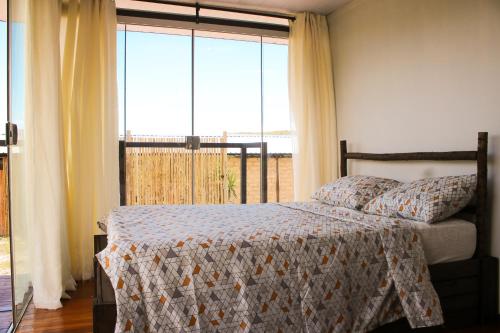 um quarto com uma cama e uma grande janela em Dolaço na Chapada- Hospedagem em Alto Paraíso de Goiás