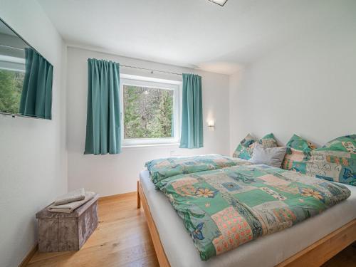 a bedroom with a bed and a window with blue curtains at Apartment Leiter in Bramberg am Wildkogel