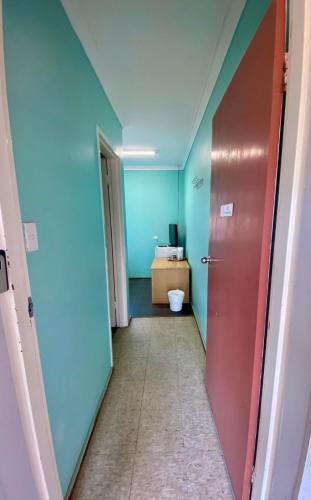 un pasillo con una habitación con paredes azules y una puerta en Bruce Rock Roadhouse and Motel, en Bruce Rock