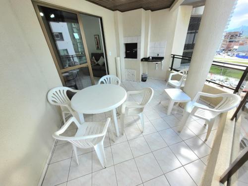- Balcón con mesa blanca y sillas blancas en Apartamento 200 metros da praia 03 quartos com ar condicionado - Meia Praia - Itapema, en Itapema