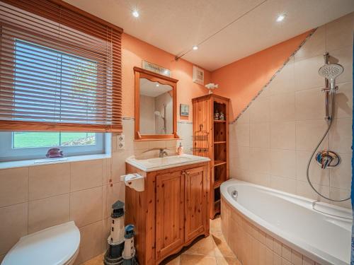 a bathroom with a tub and a sink and a toilet at Panoramahaus Itter in Itter