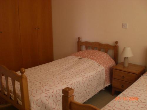 a bedroom with two twin beds and a night stand at St. Lazaros Seaside Apartment in Larnaca