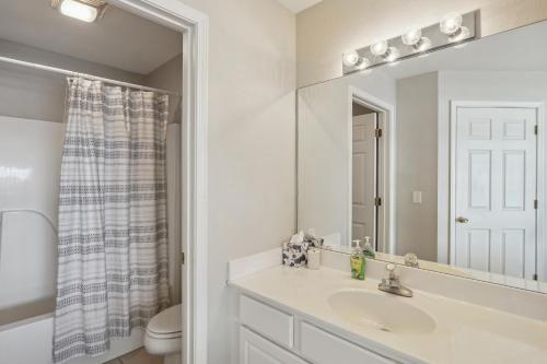 uma casa de banho branca com um lavatório e um espelho em Lake Ozark Condo with Screened Balcony and Lake Views! em Lake Ozark