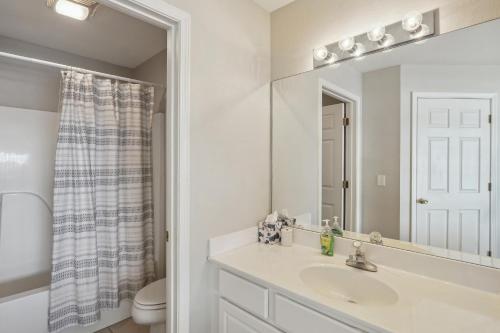 a white bathroom with a sink and a mirror at Condo with Balcony and Views in Lake of the Ozarks in Lake Ozark