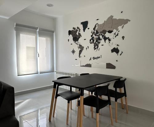 a dining room table with chairs and a world map on the wall at Urbano Esquel in Esquel