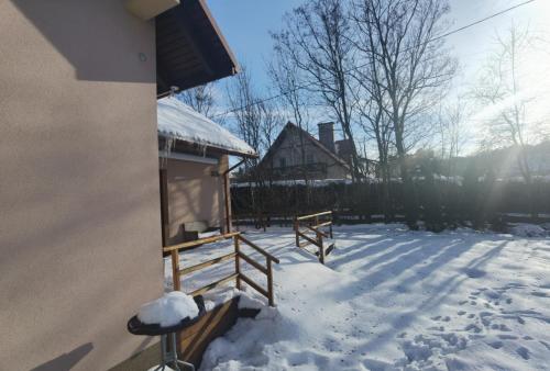 a snow covered yard with a house and a fence at Akacja Apartament in Rzeszów