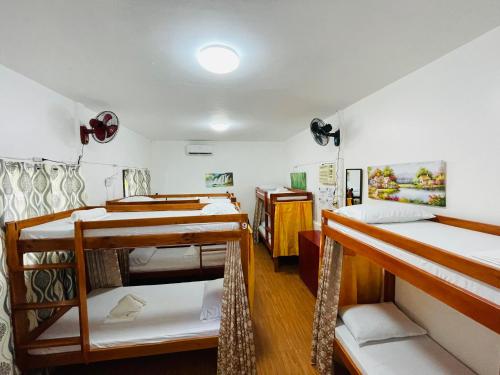 a dorm room with four bunk beds in it at 3 Sisters Guest House 1 in Moalboal